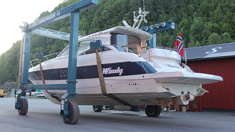 Stor båt løftes med Marine Travelift for vedlikehold.